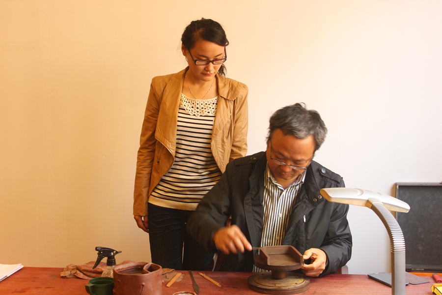 紫砂壶图片：在接受师傅蒋彦的指导 - 宜兴紫砂壶网